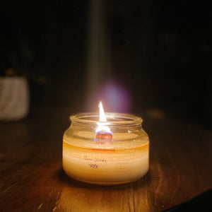scented soy candle with wood wick burning at night